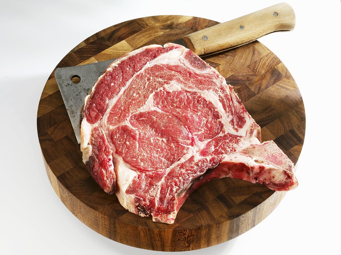 Raw Porterhouse steak with meat cleaver