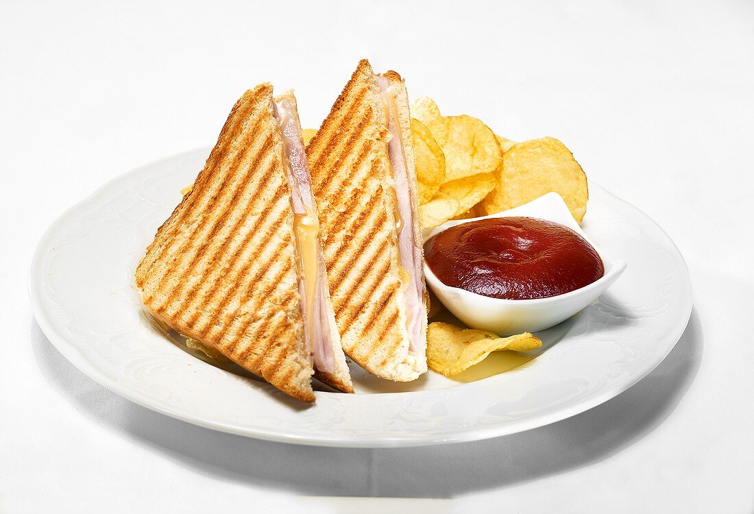 Toasted ham and cheese sandwiches with ketchup and crisps