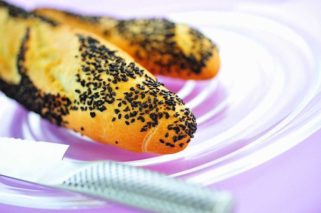 Poppy seed baguettes on glass plate