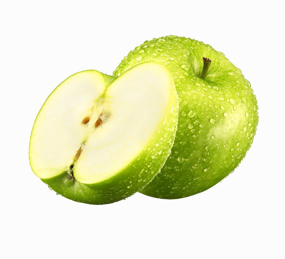 Ganzer und halber grüner Apfel mit Wassertropfen