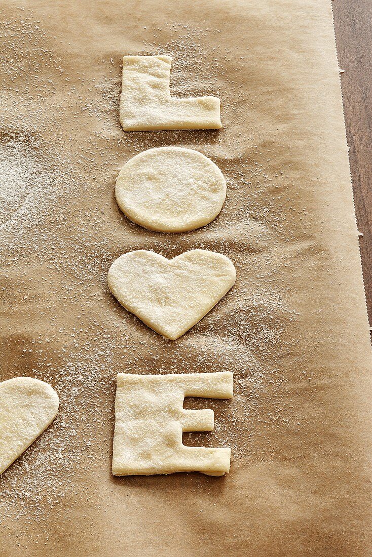 Ausgestochene LOVE-Kekse auf Backpapier