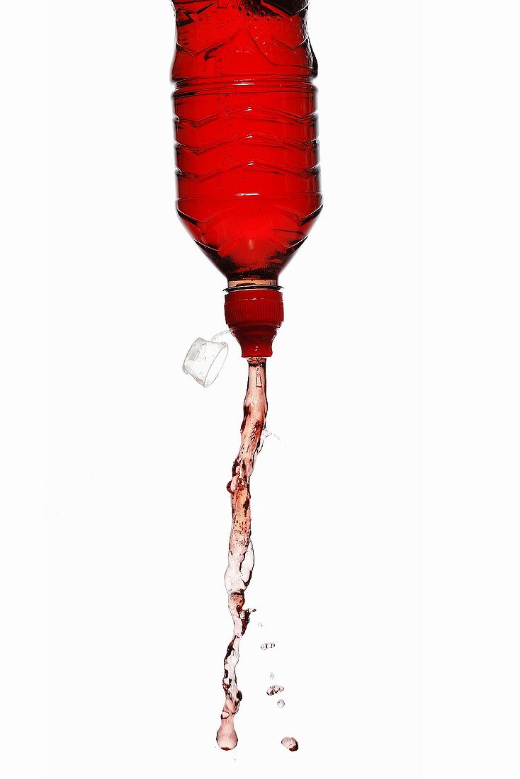 Red energy drink squirting out of bottle – License Images – 996198 ❘  StockFood