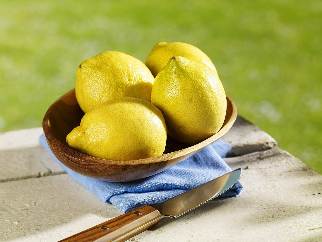 Several lemons in wooden bowl