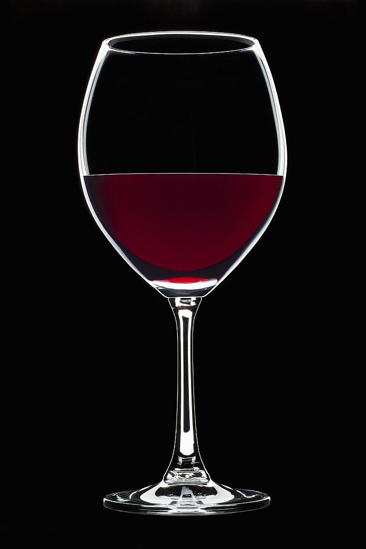 Glass of red wine against black background