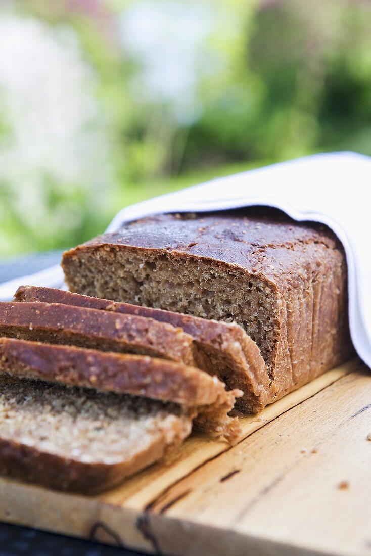 Vollkornbrot, angeschnitten, auf Holztisch