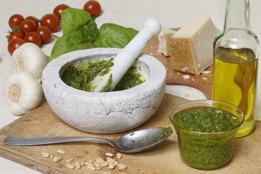 Pesto in mortar surrounded by ingredients