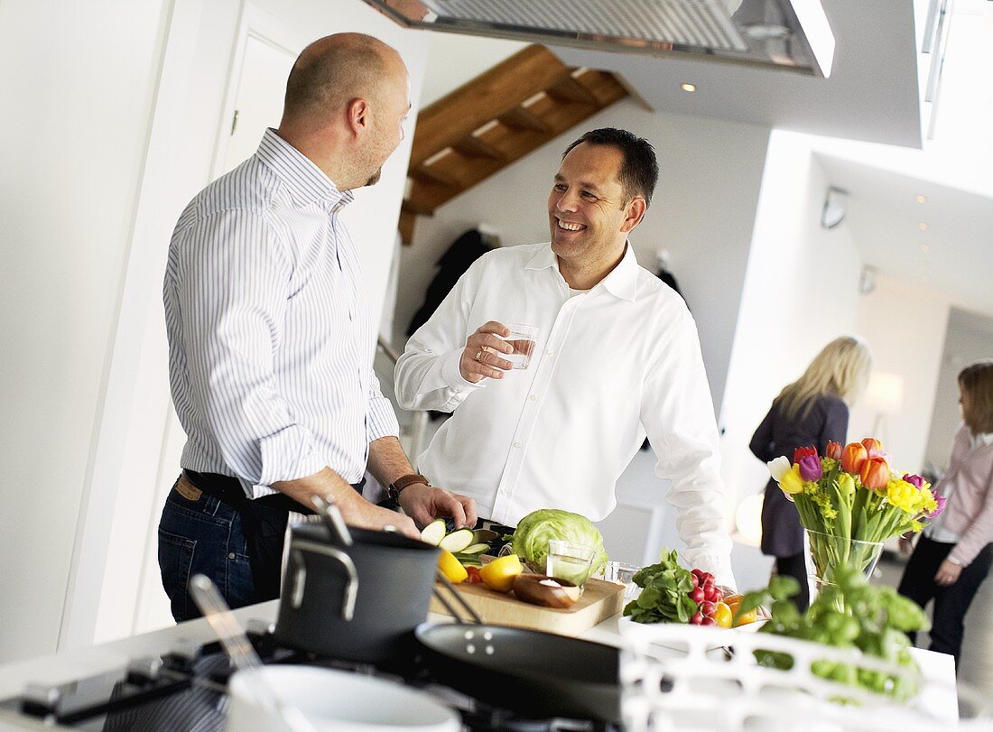 Two men chatting in kitchen