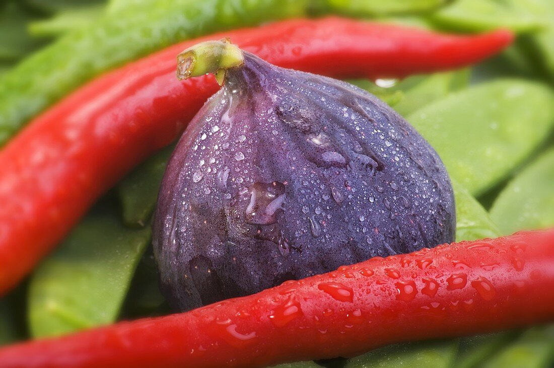 Fig, chillies and mangetout with drops of water (close-up)