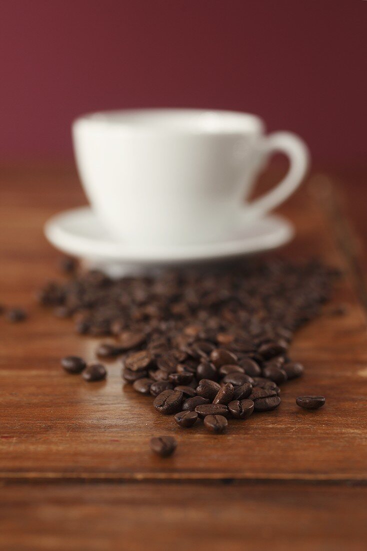 Coffee cup and coffee beans on wooden table