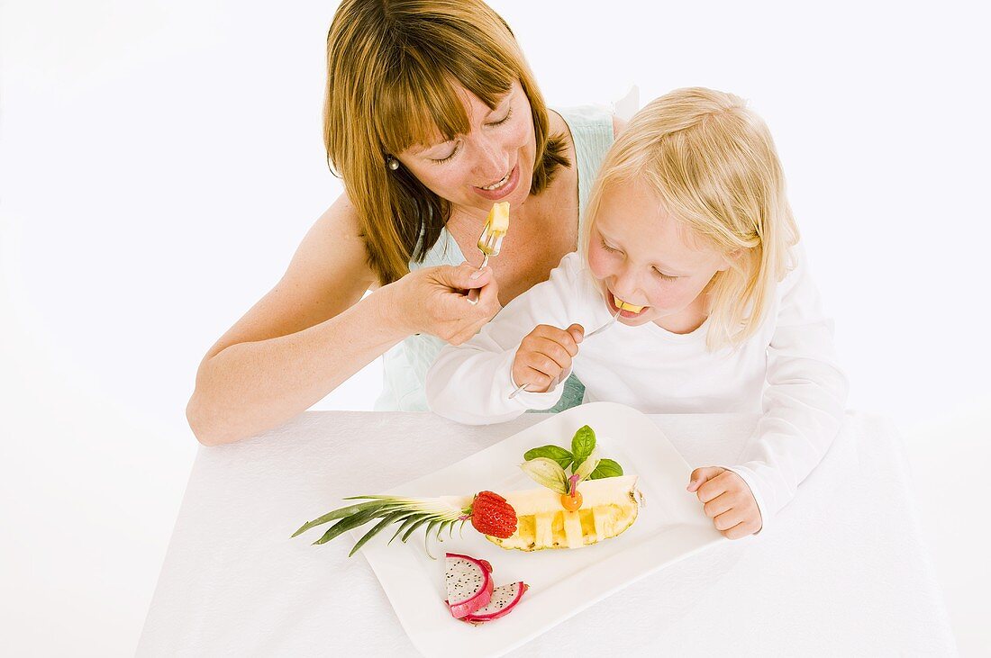 Mutter und Tochter essen Obst vom Obstteller