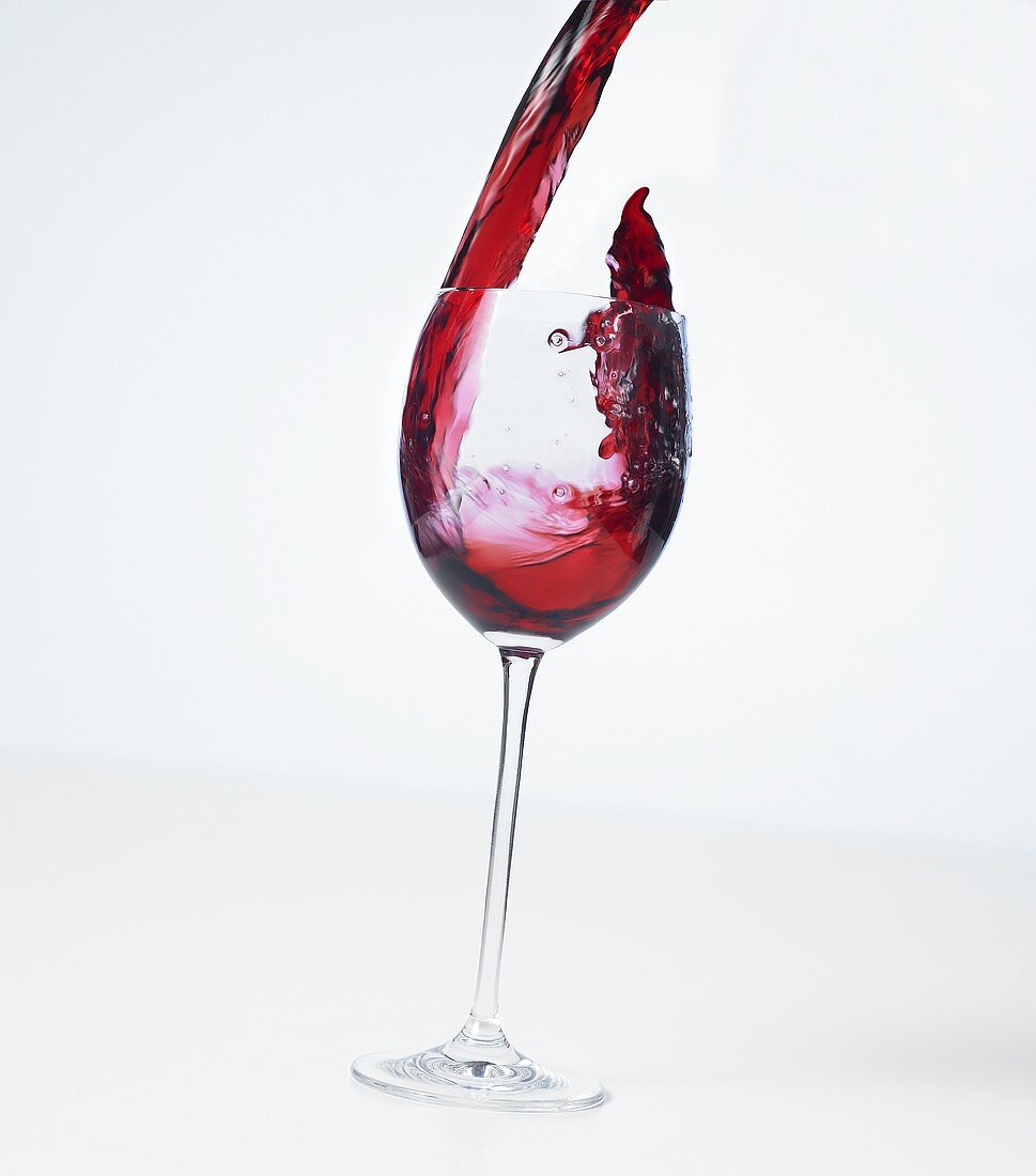 Pouring red wine into a glass (splash)