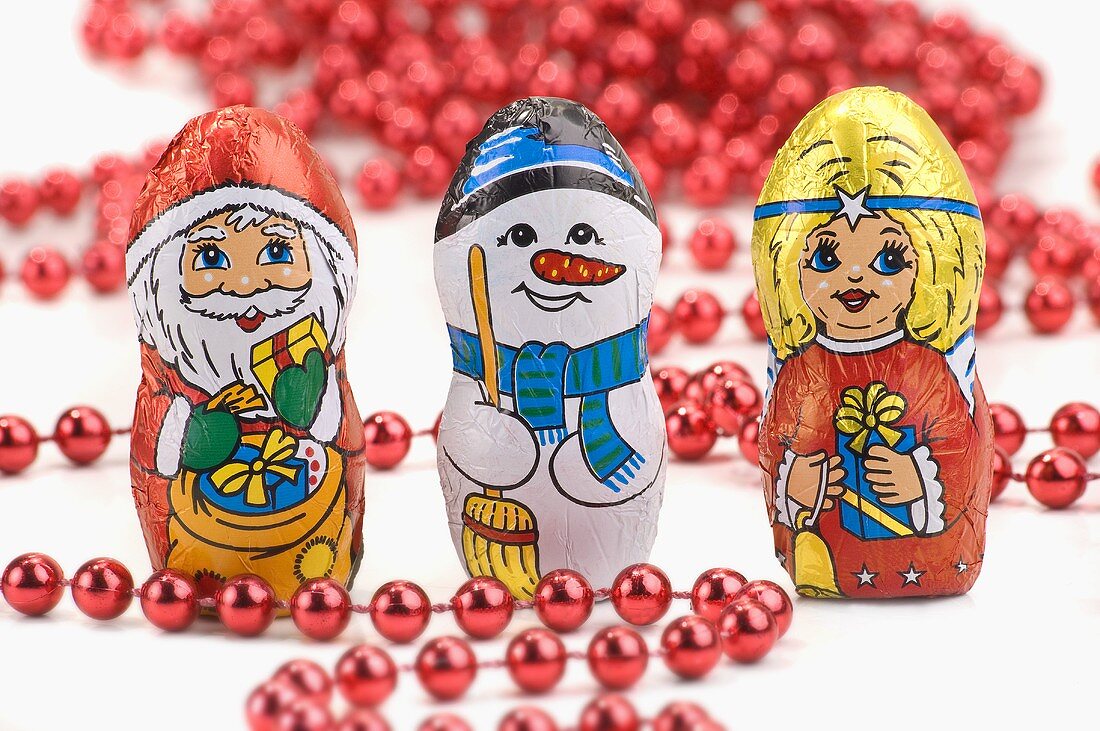 Weihnachtliche Schokoladenfiguren (Nikolaus, Schneemann, Christkind) und Perlenkette