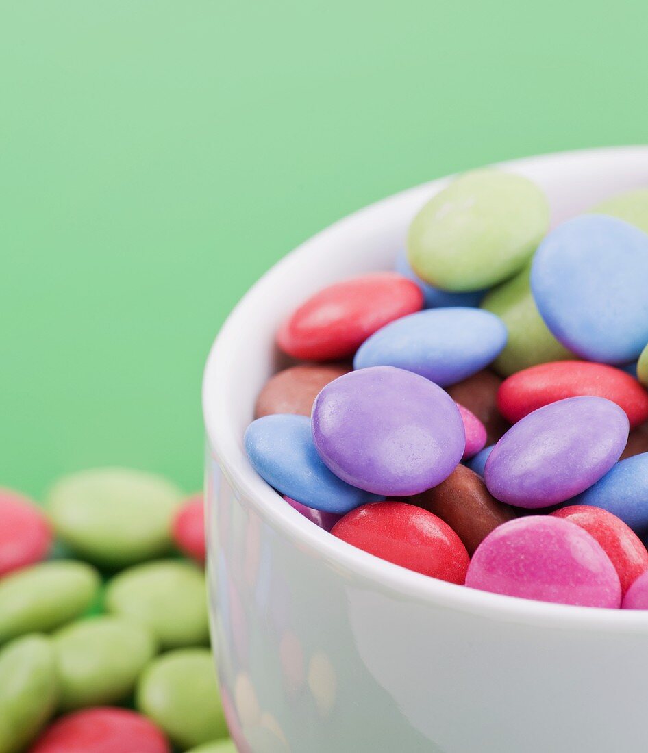Coloured chocolate beans in bowl (close-up)