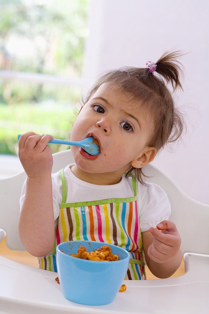 Girl eating pasta with bolognese sauce