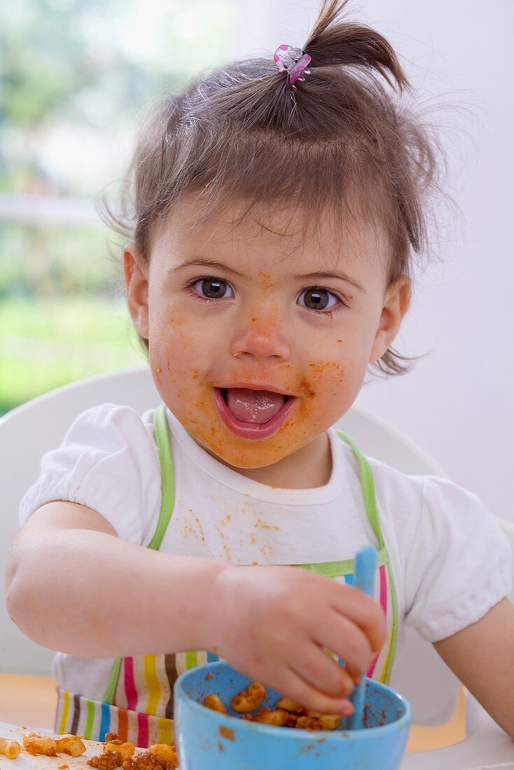 Girl eating pasta with bolognese sauce