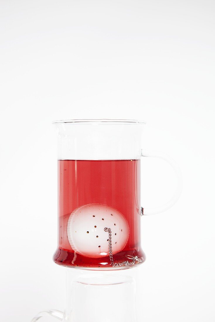 Fruit tea in glass with tea infuser