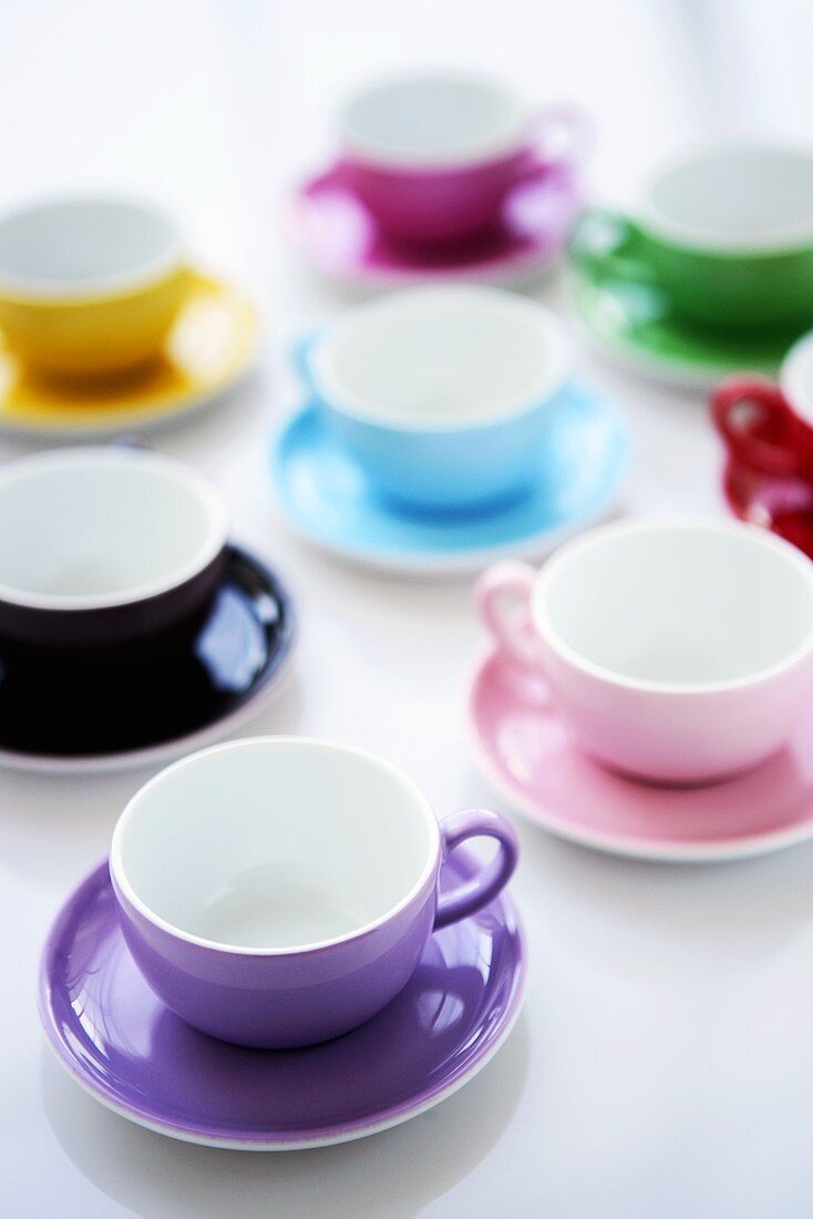 Several coloured coffee cups and saucers