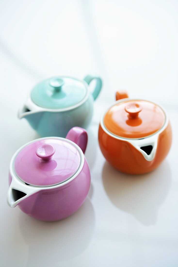 Three coloured teapots