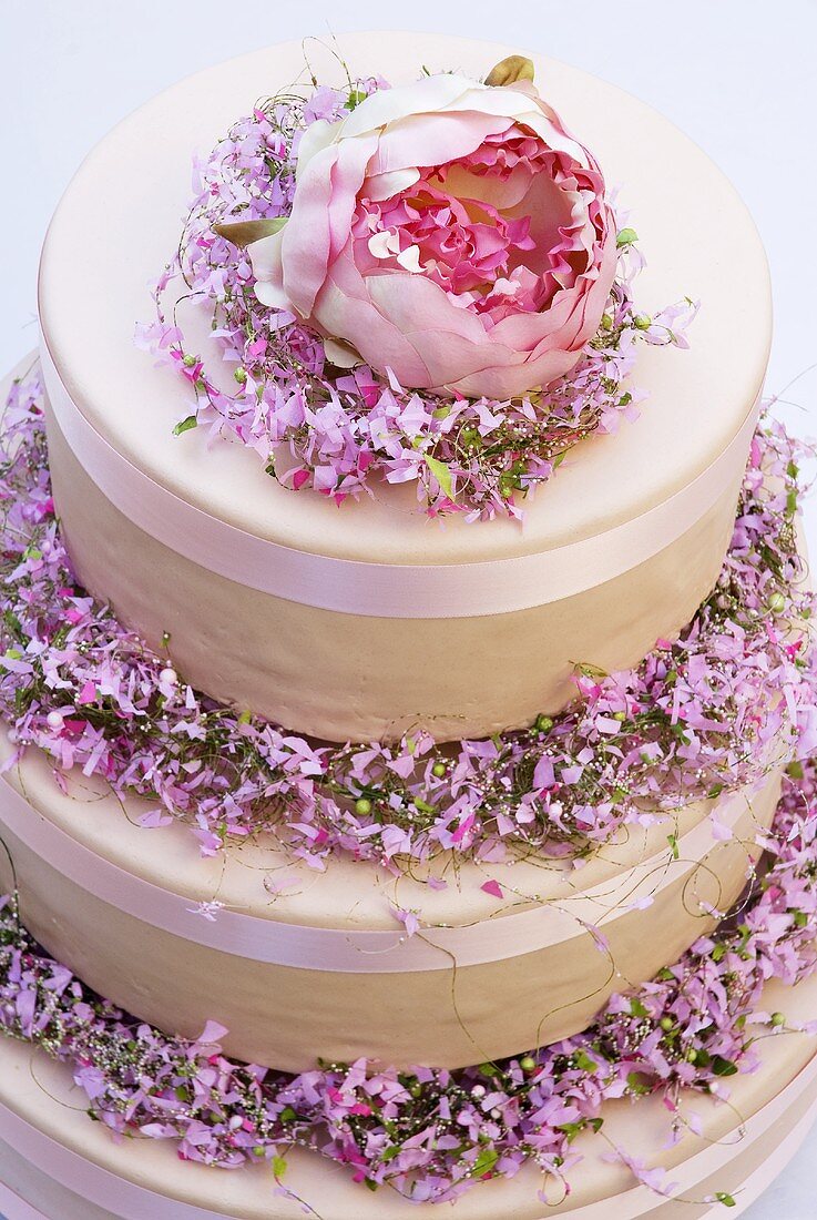 Three-tiered cream cake with spring flowers