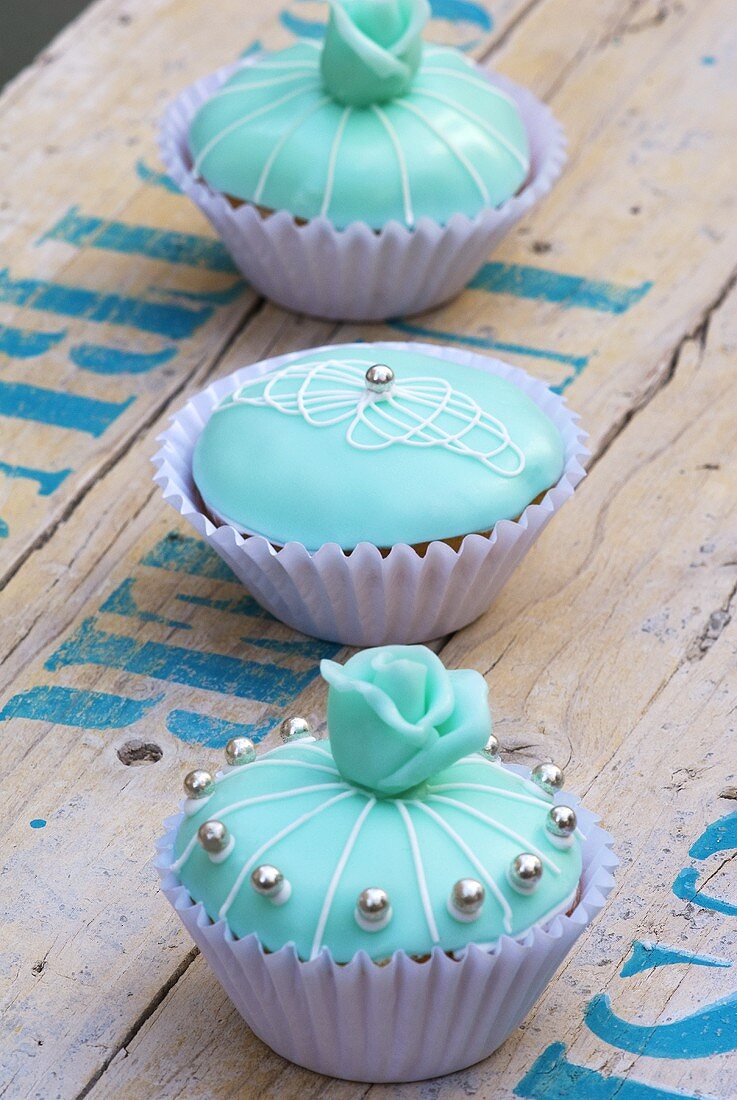 Three turquoise cupcakes with silver dragees