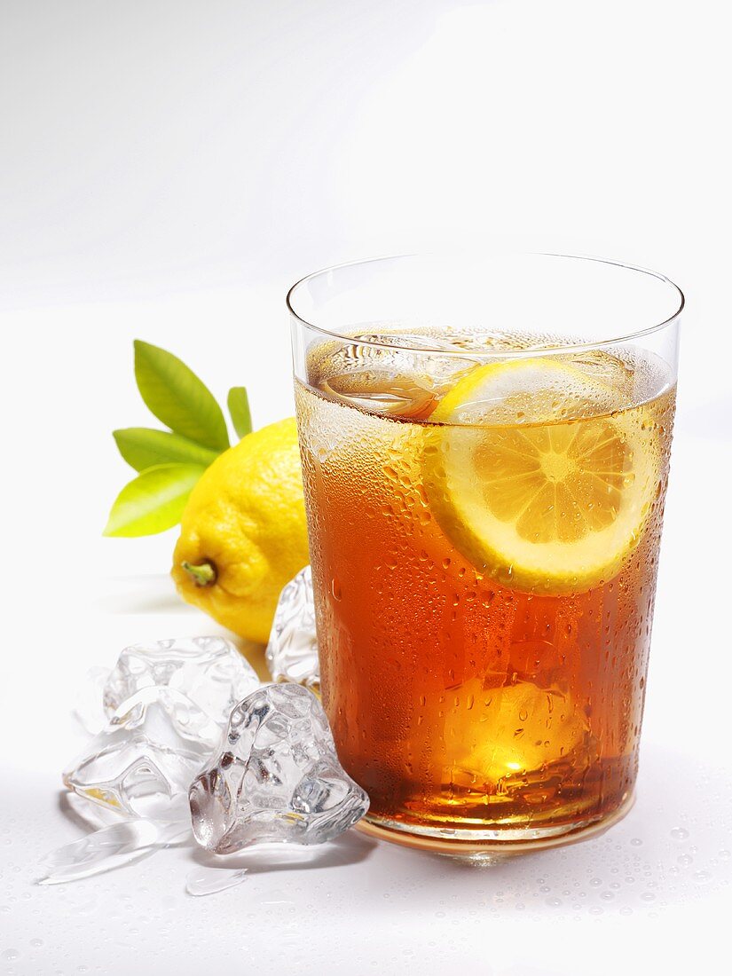 Glass of iced tea with lemon and ice cubes