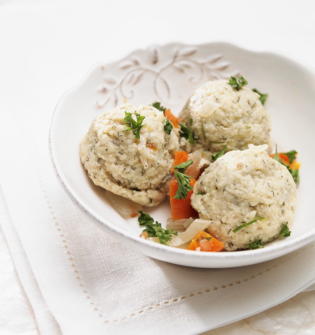 Matzah Balls with Carrots and Parsley in a White Bowl