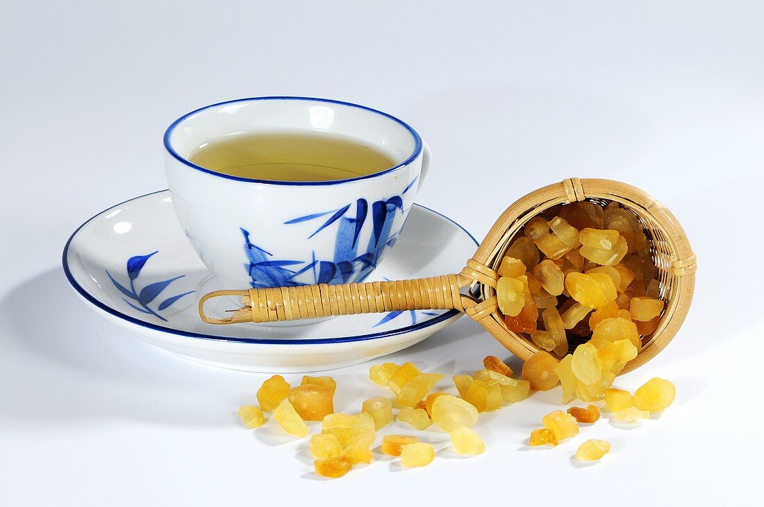 Chinese asparagus root in tea strainer, cup of tea