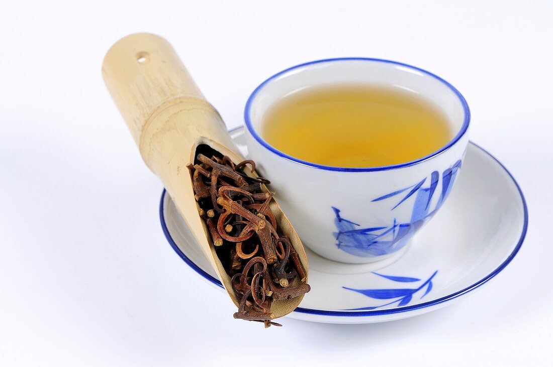 Uncaria-Zweige und Dornen mit einer Tasse Tee