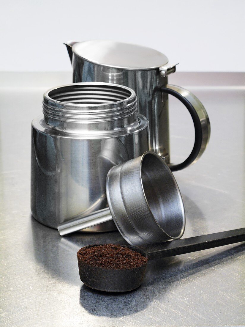 Espresso maker and scoop full of ground coffee