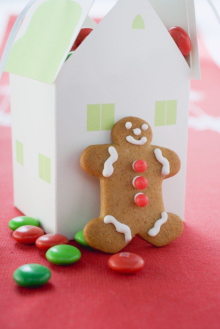 Gingerbread man and paper house full of chocolate beans