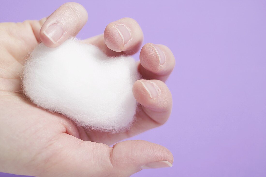 Hand holding cotton wool ball