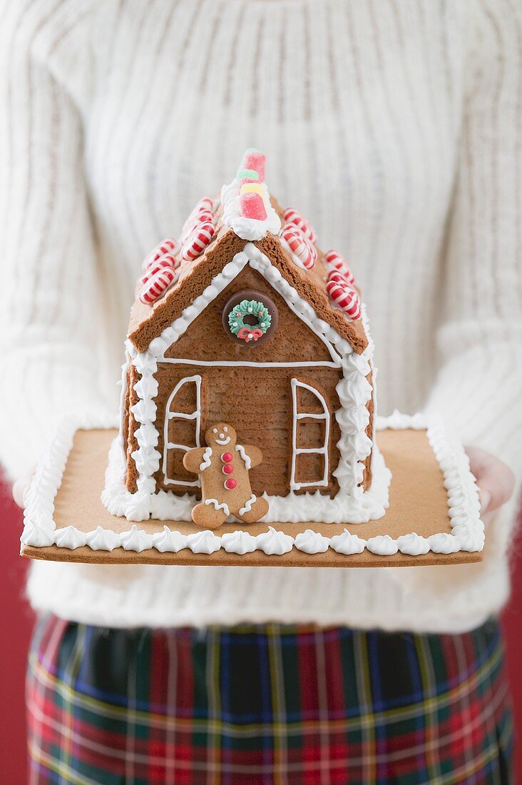 Frau hält Lebkuchenhaus