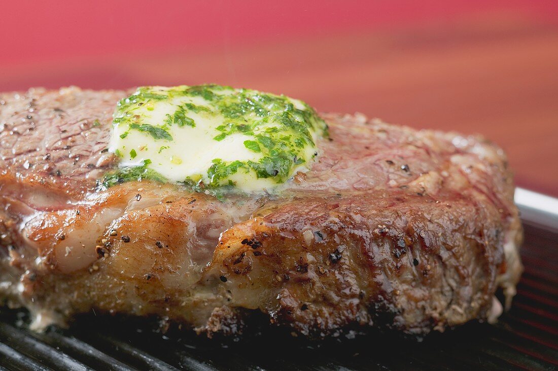 Rindersteak mit Kräuterbutter auf dem Grill (Close Up)