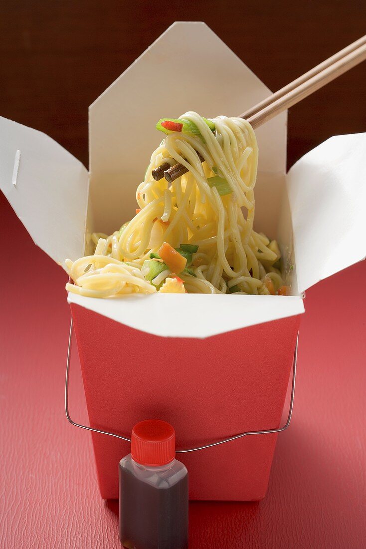 Noodles with vegetables in take-away container, soy sauce