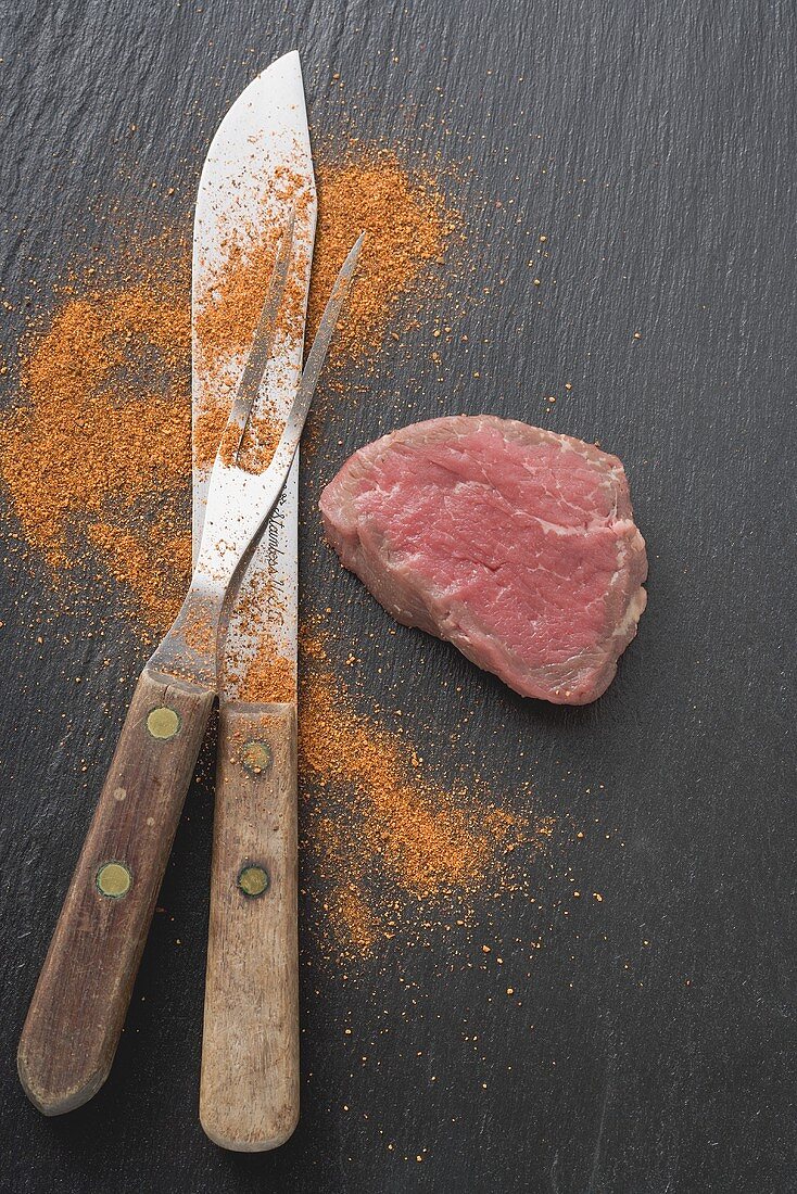 Fillet steak, carving fork, knife and spice