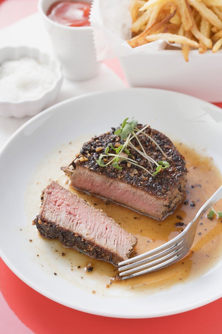 Pfeffersteak mit Kresse, Pommes frites, Salz und Ketchup