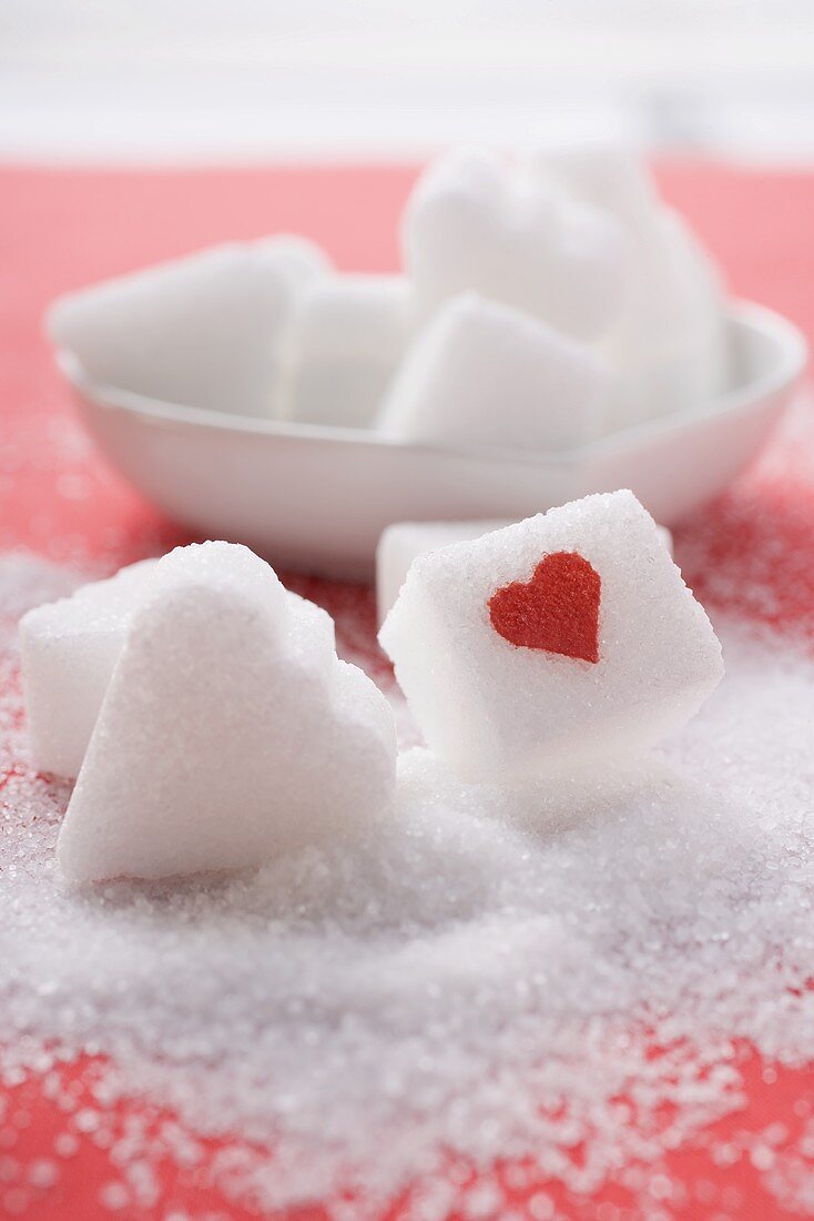 Zuckerwürfel mit rotem Herz und herzförmige Zuckerwürfel