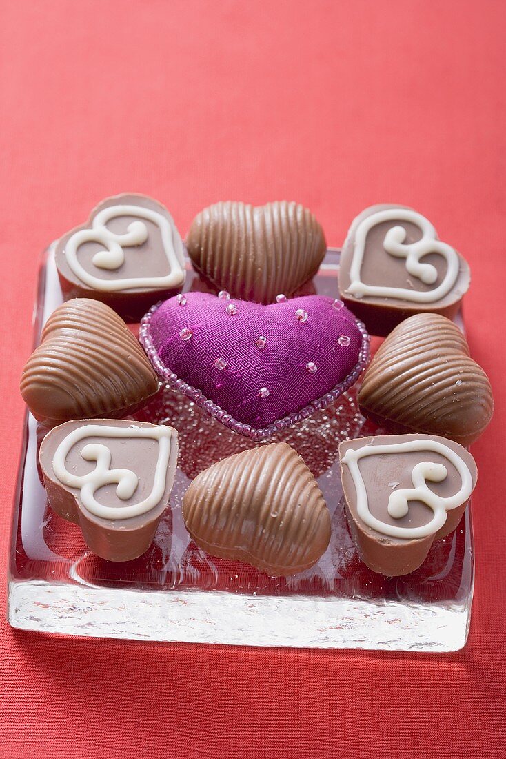 Purple fabric heart surrounded by chocolates