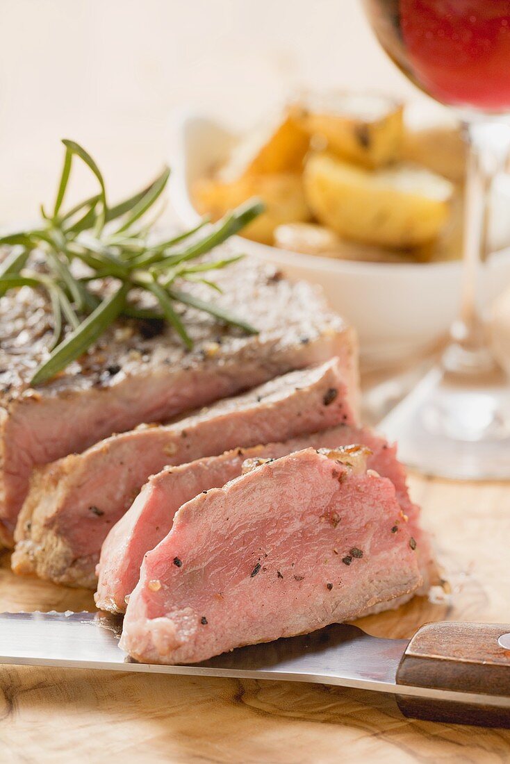 Filetsteak mit Rosmarin, Bratkartoffeln, Glas Rotwein