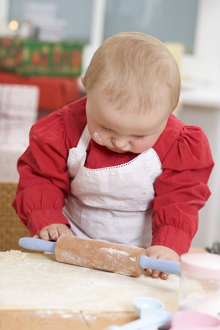 Baby rolling out dough