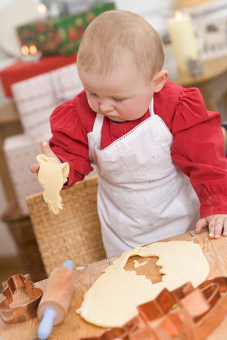 Baby holding cut-out Christmas biscuit