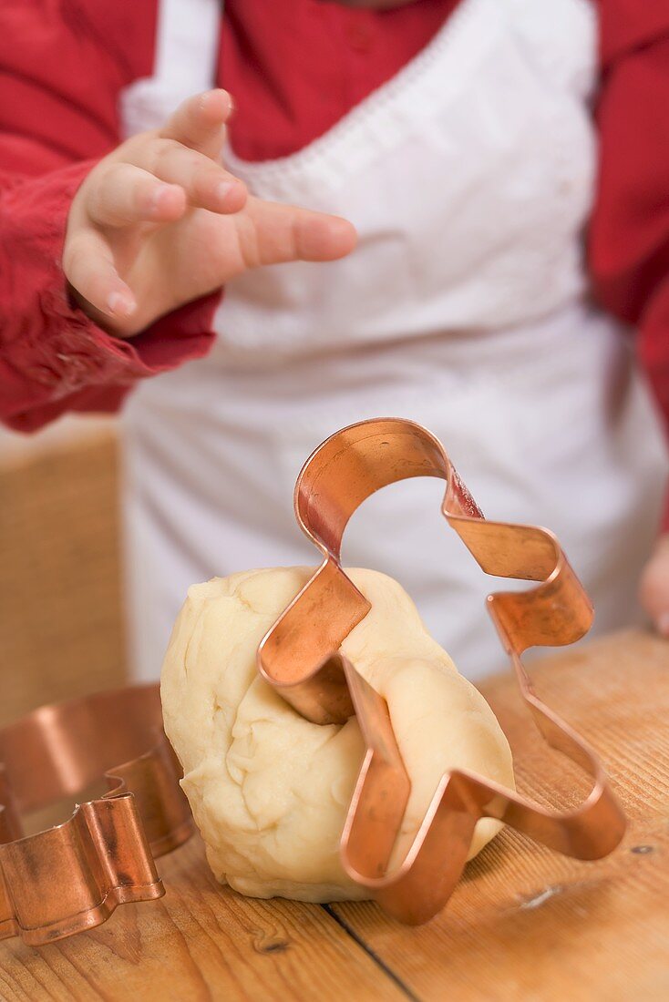 Baby reaching for gingerbread man cutter