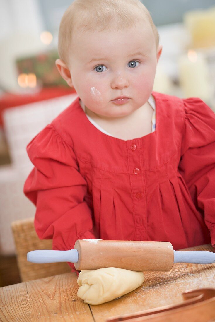 Toddler with rolling pin and ball of dough