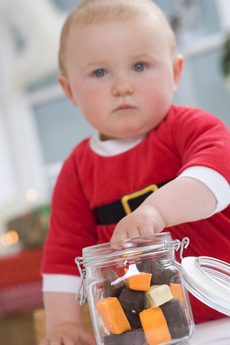 Baby taking sweets out of storage jar