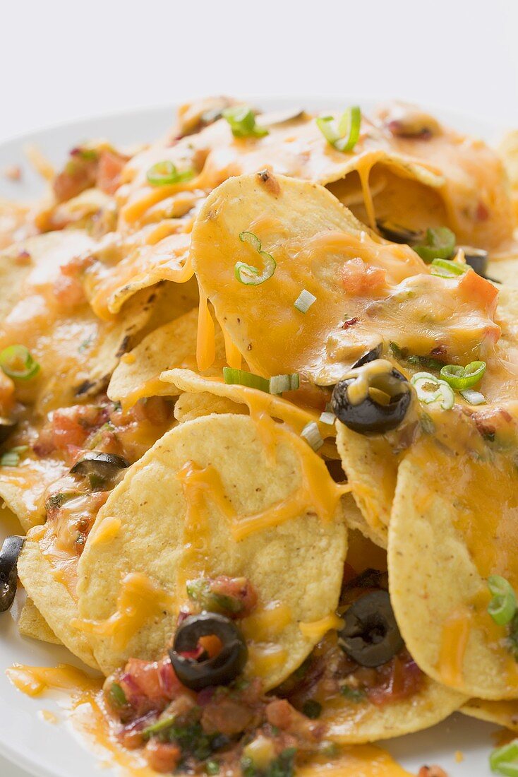Tortilla chips with melted cheese and olives