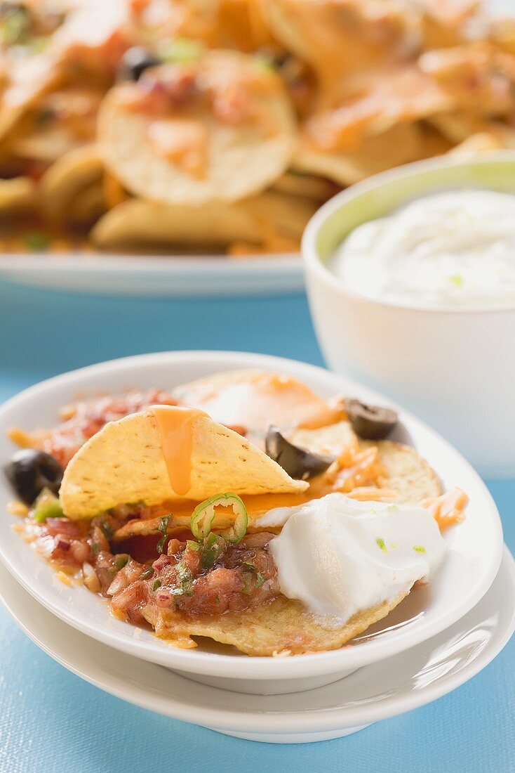 Überbackene Tortillachips mit Käse, Oliven und saurer Sahne