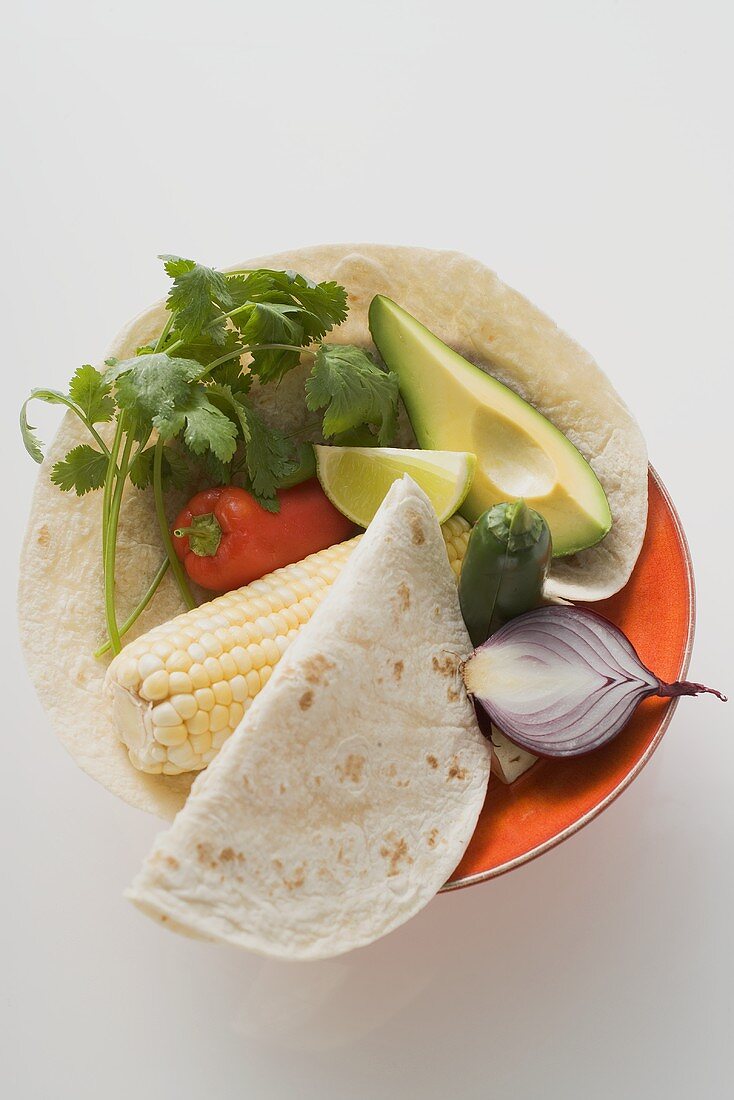 Ingredients for Mexican dishes on plate (overhead view)