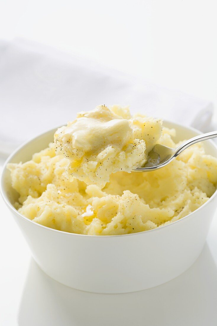 Kartoffelpüree mit Butter in Schale und auf Löffel