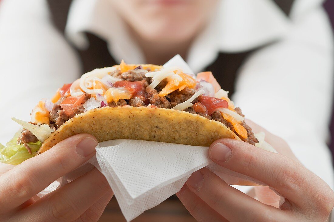 Woman holding mince taco
