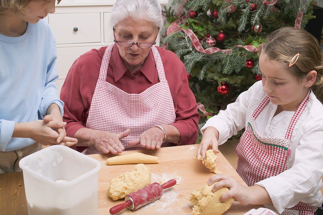 Grandmother and two grandchildren baking for Christmas